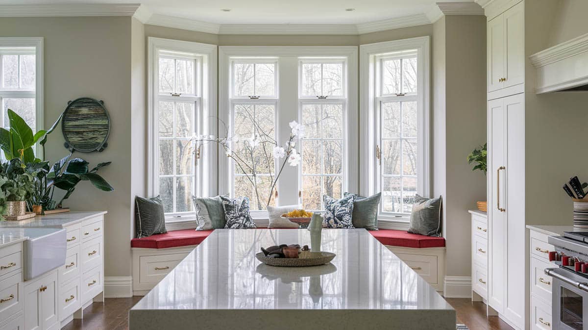 Traditional kitchen with beautiful bow window with red cushion seat 