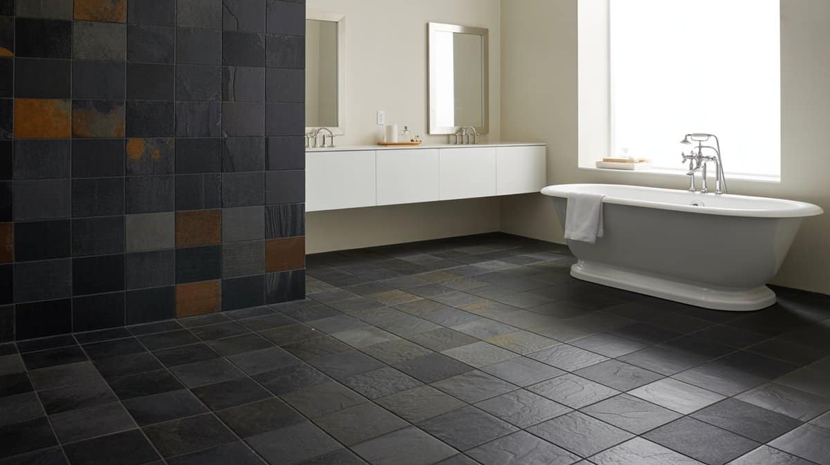 Bathroom with dark multicolor slate tile floor and accent wall with white tub