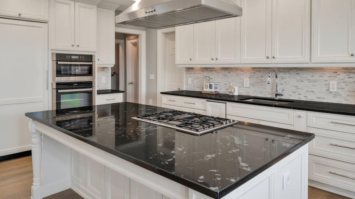 White shaker kitchen with bold galaxy speckled black granite island and built-in gas cooktop